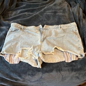 Light wash jean shorts with blue/white striped pockets
